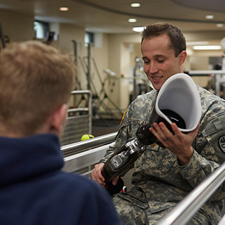 A military physician holds a prosthetic leg. A military physician holds a prosthetic leg.