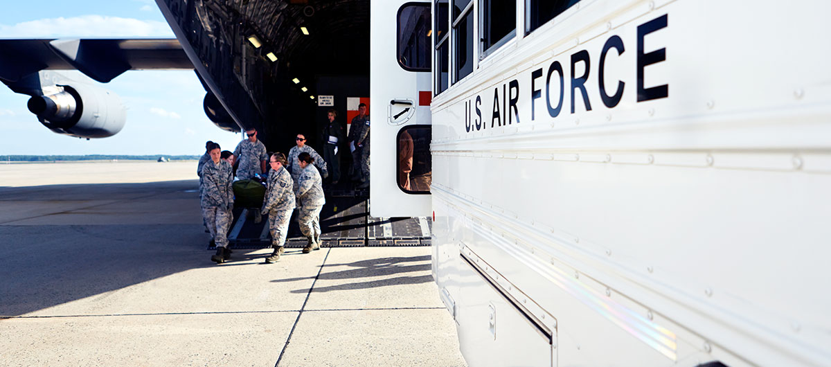 Air Force medical professionals carry a stretcher out of a plane during a training exercise.