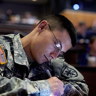 A military medical student takes notes in class. A military medical student takes notes in class.