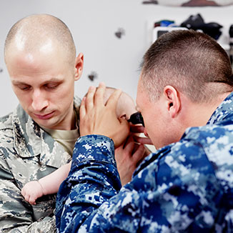 A military physician evaluates the child of a service member. A military physician evaluates the child of a service member.