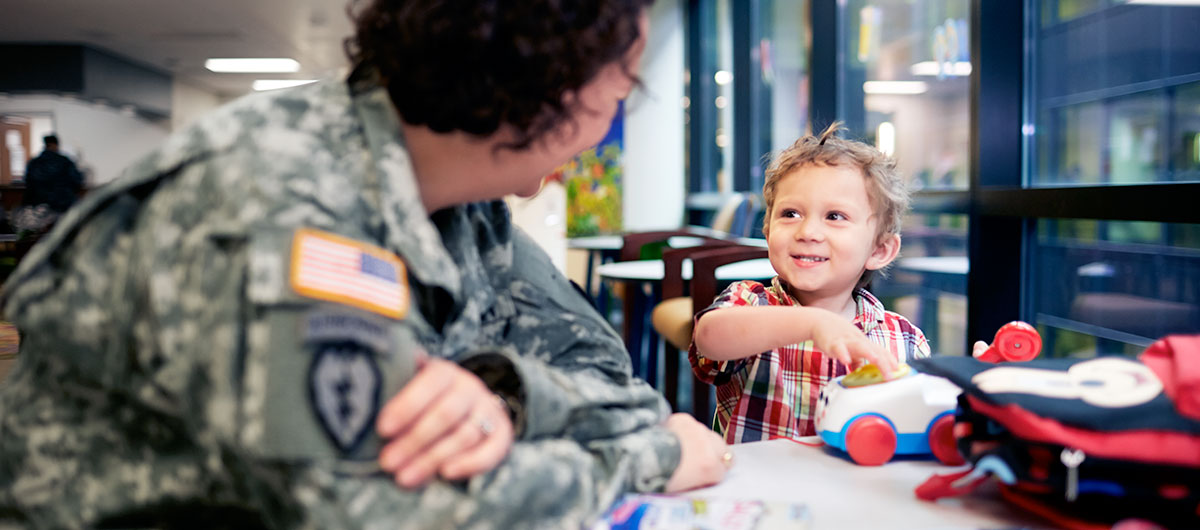 A military physician brightens a young patient's day.