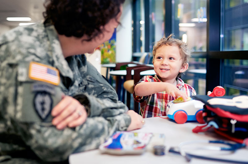 A military physician brightens a young patient's day.