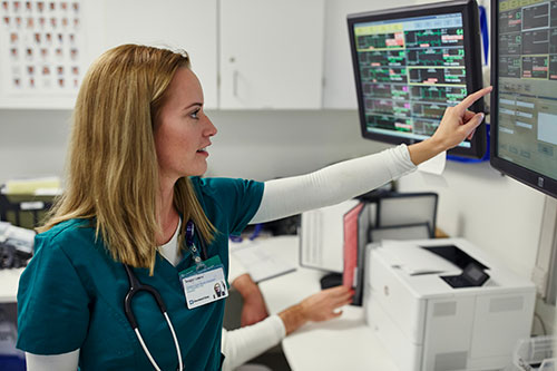A health care service member checks information on a computer screen