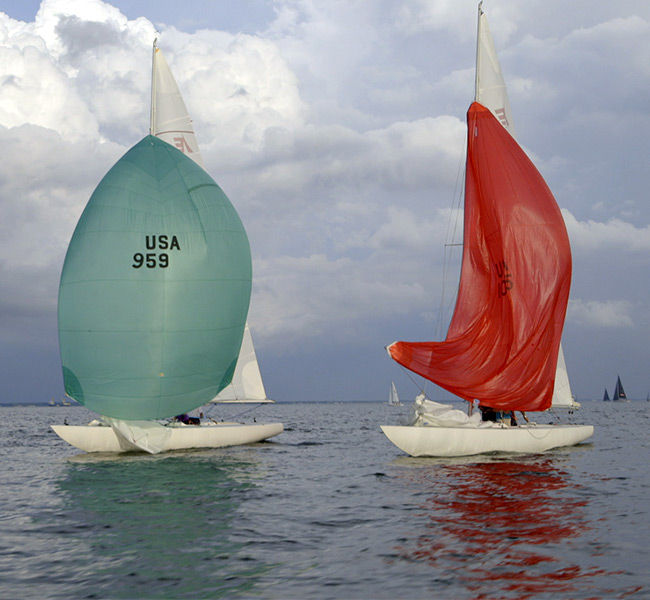 three sailboats in a race with their spinnakers up