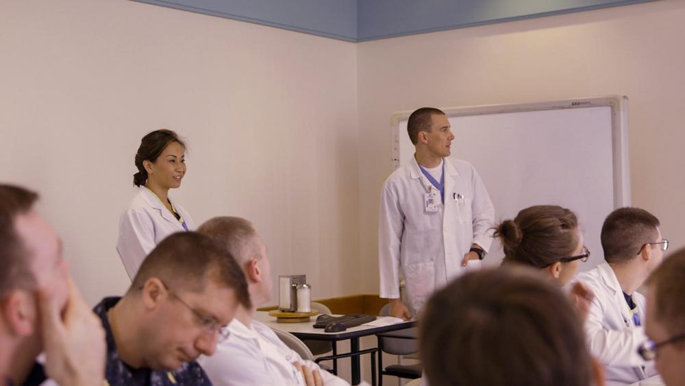 Josephine and matt standing in front of a class 