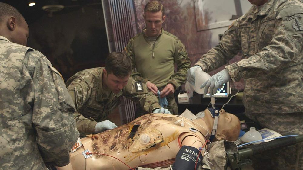 medics performing an escharotomy on simulation mannequin