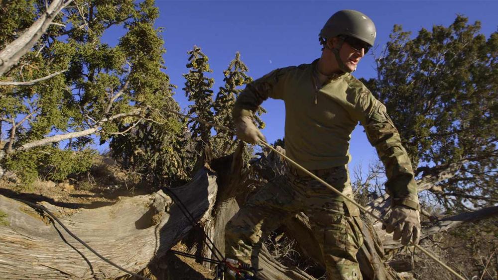 Hunter uses rope to walk up cliff 