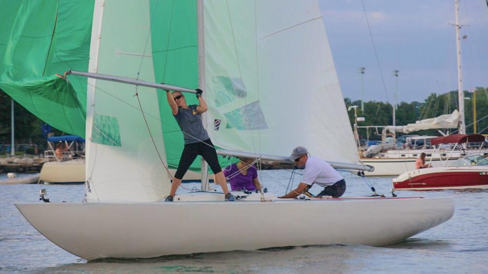 Dawn standing on sailboat holding sails 