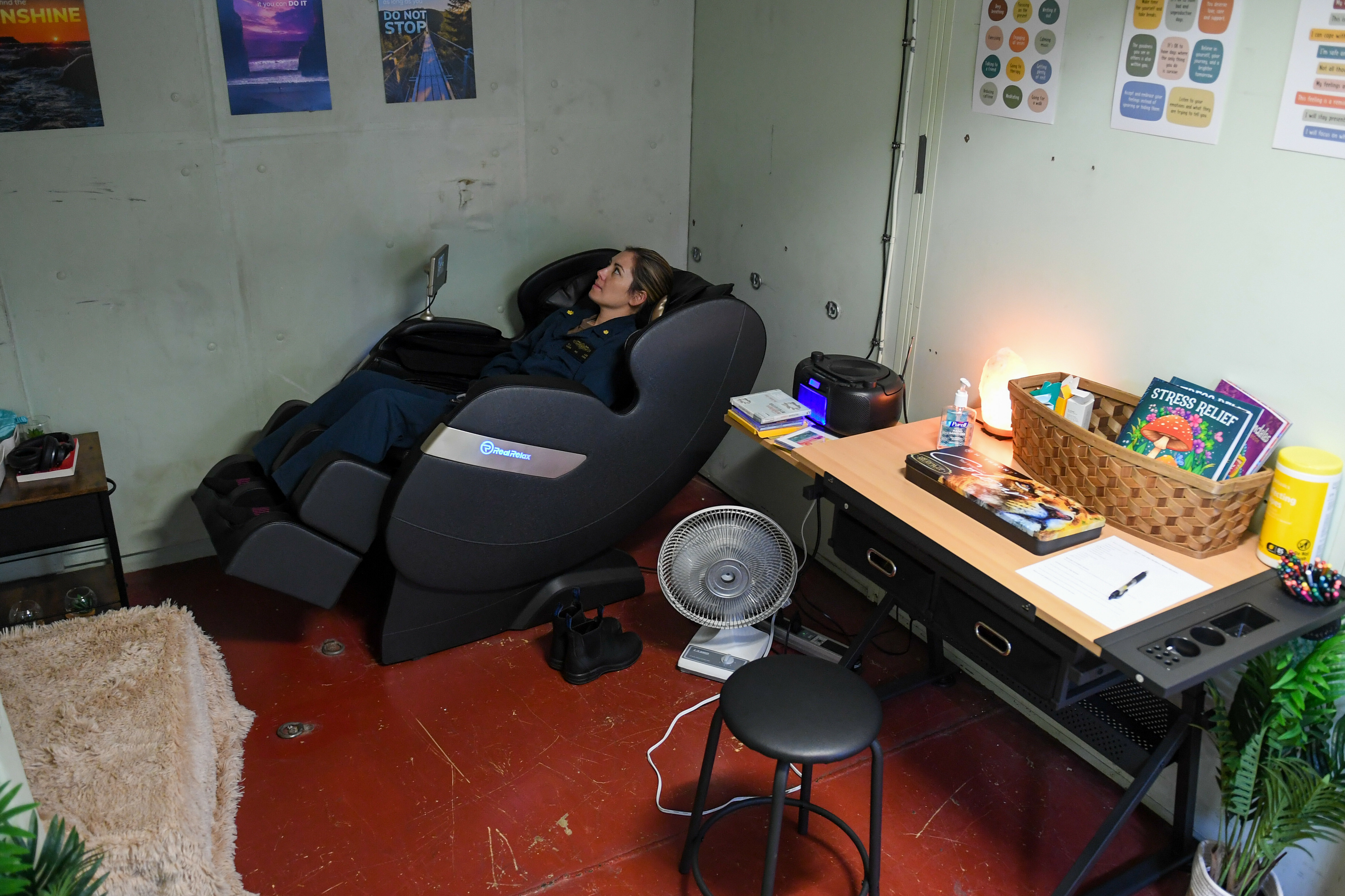 U.S. Lt. Cmdr. Katie Lee, an ER doctor, relaxes in a massage chair in the resiliency room aboard the hospital ship USNS Mercy 