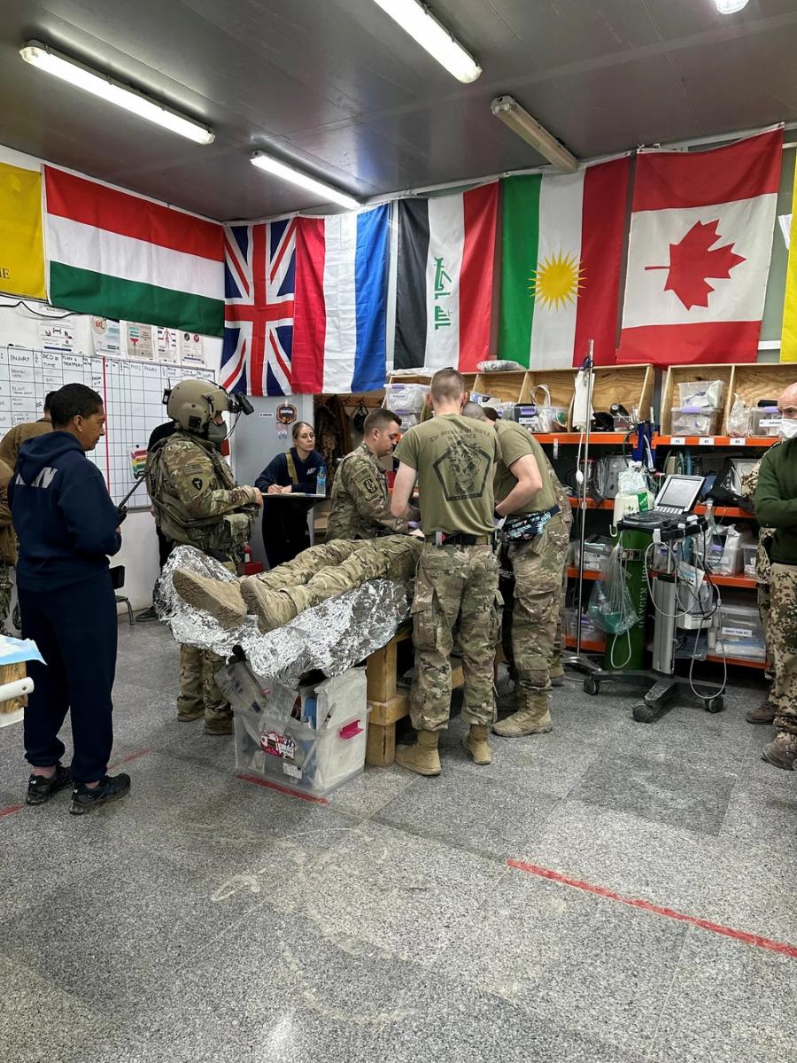 230322-N-N1526-0001 Erbil Air Base, Iraq (March 22, 2023) Cmdr. Katharina Pellegrin, left, the trauma director, and intensive care unit nurse Lt. Leah Wiltshire, far back right, both assigned to Navy Expeditionary Medical Unit 10- Gulf (NEMU 10G), Rotation 13, monitor Army medics assigned to the 709th Medical Company Area Support (MCAS), as they receive a report during a mass casualty exercise, March 22, 2023.