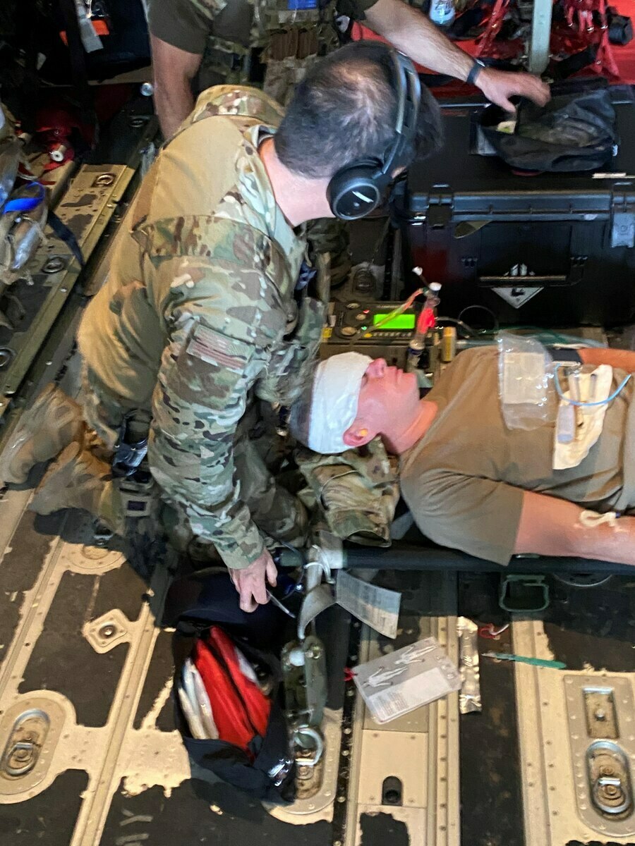 A Tactical Medical Augmentation Team Airman administers patient care to a simulated patient aboard an HC-130J Combat King II aircraft. 